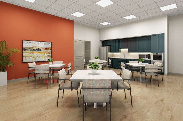 A modern dining area with several tables, chairs, and a kitchen setup.
