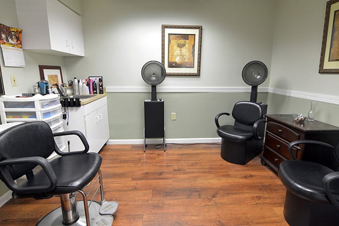 A well-organized hair salon with chairs, a hair drying station, and stylish decor.