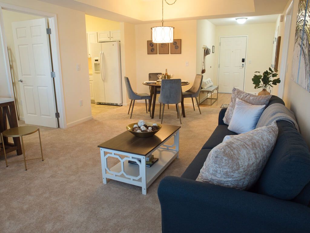 A cozy living room and dining area featuring modern furniture and warm lighting.