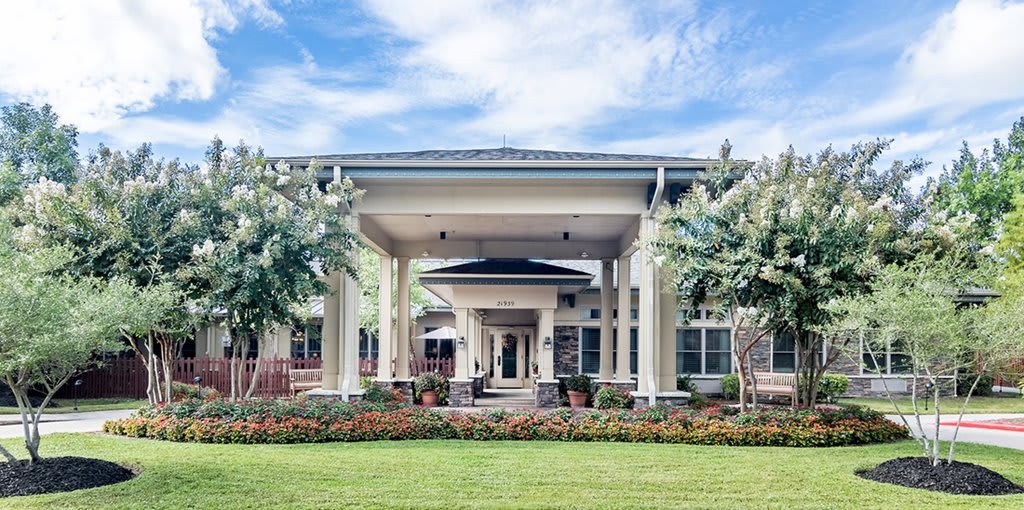 A modern building entrance with tall columns and landscaped surroundings.