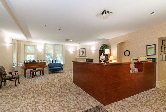 A spacious office reception area with a wooden desk and comfortable seating.