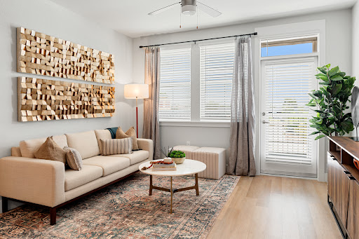 A stylish and inviting living room featuring a beige sofa, modern coffee table, and natural light streaming through the windows.