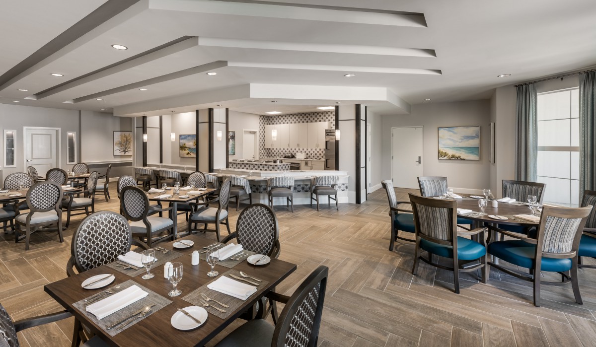 A modern restaurant interior with neatly arranged dining tables and chairs.