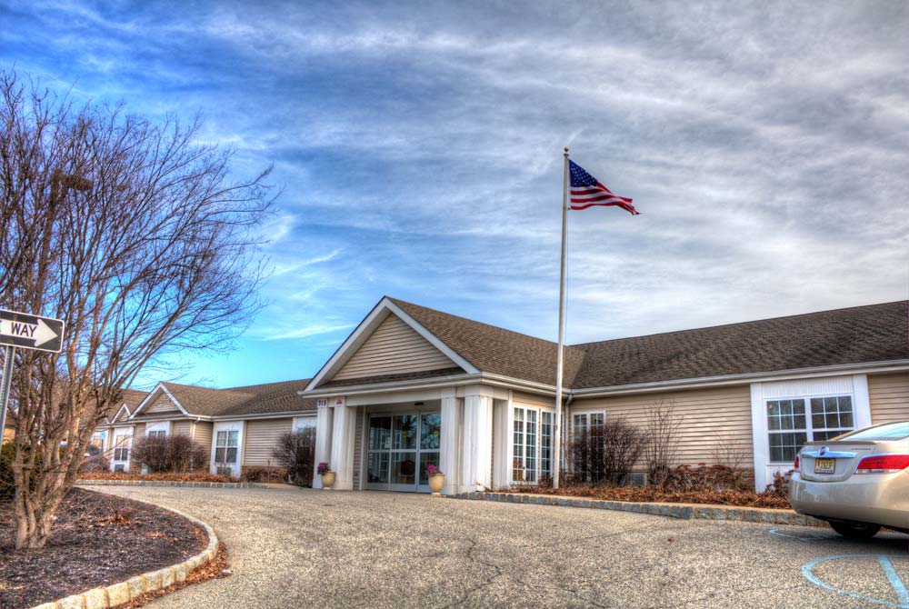 A building with an American flag flying outside under a cloudy sky.