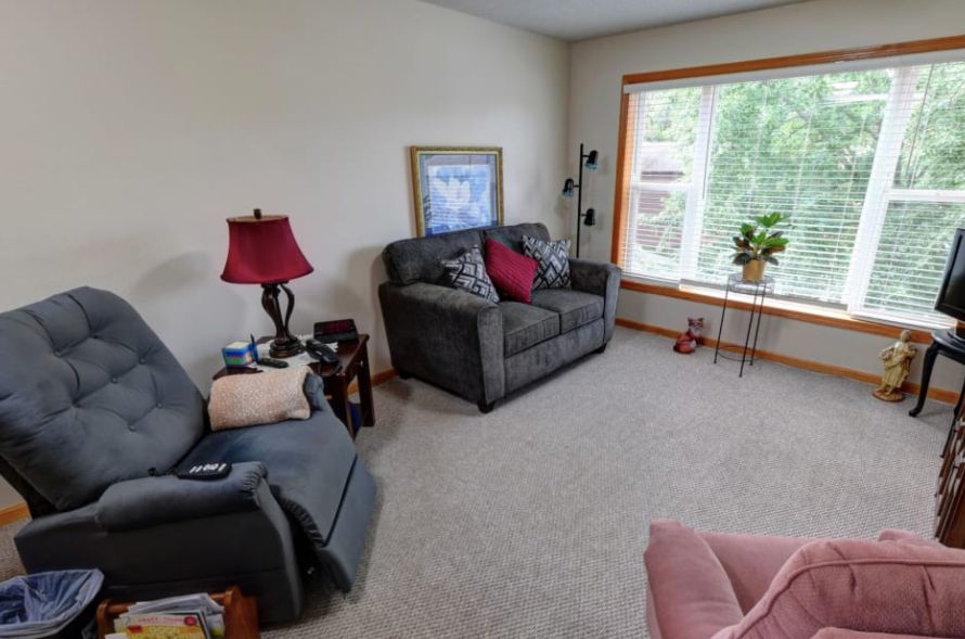 A cozy living room with a grey sofa, armchair, and decorative elements.