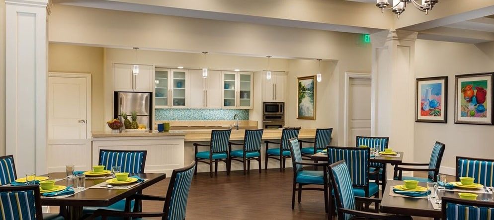A modern dining room with elegant seating and a stylish kitchen area in the background.