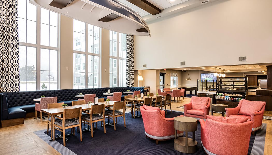 A modern lounge area with comfortable seating and large windows.