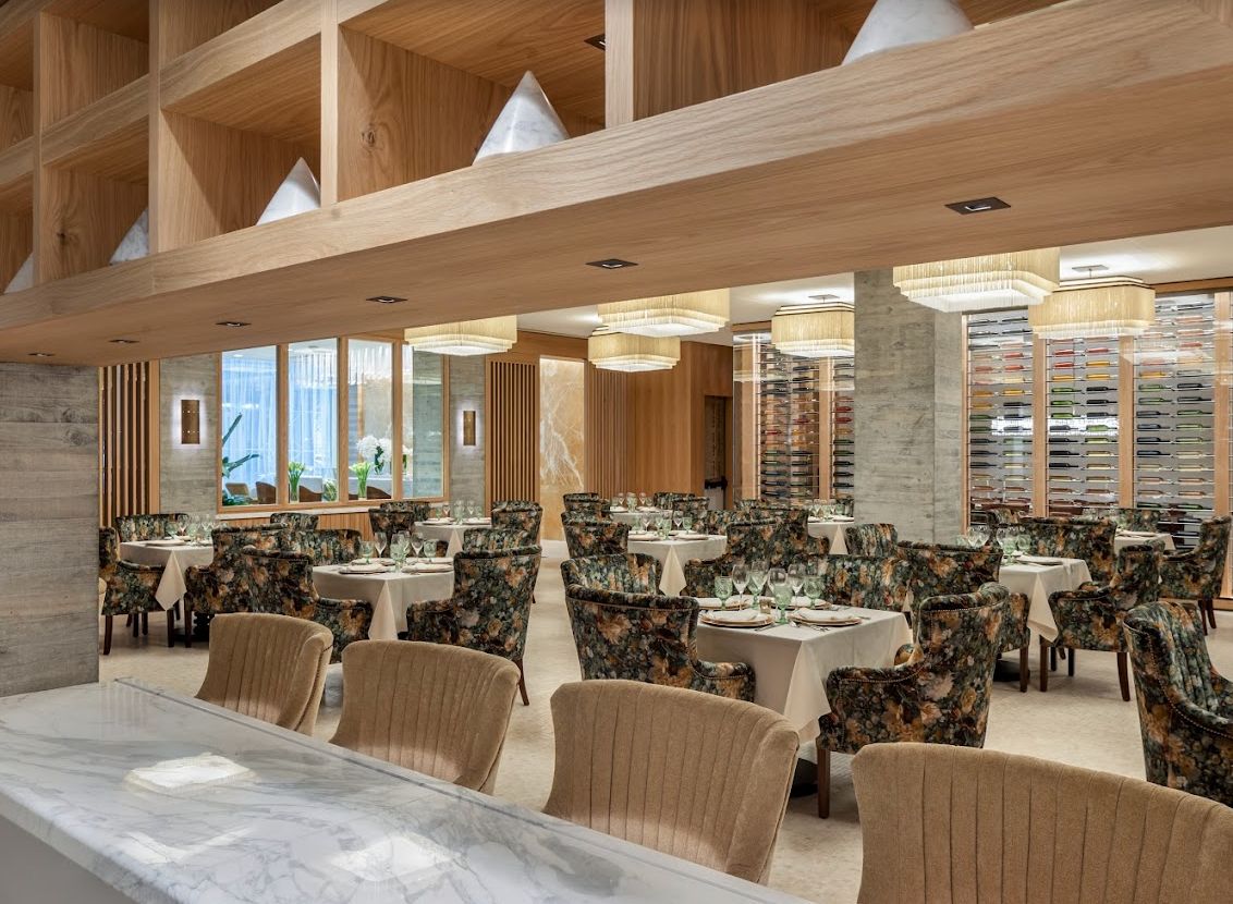 A modern restaurant interior featuring neatly arranged dining tables and chairs.