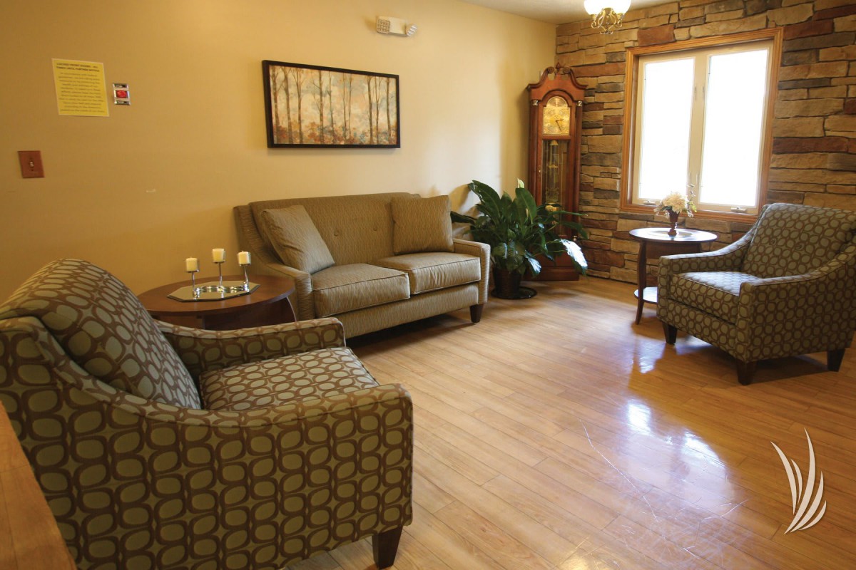 A cozy living room with comfortable seating, a grandfather clock, and decorative elements.