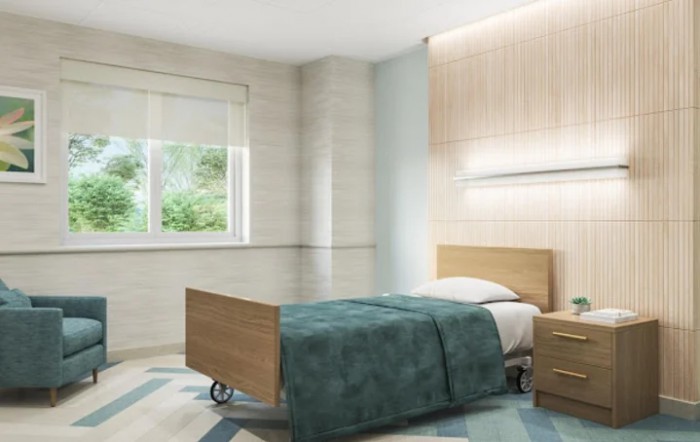 A minimalist hospital room with a single wooden bed and natural lighting.