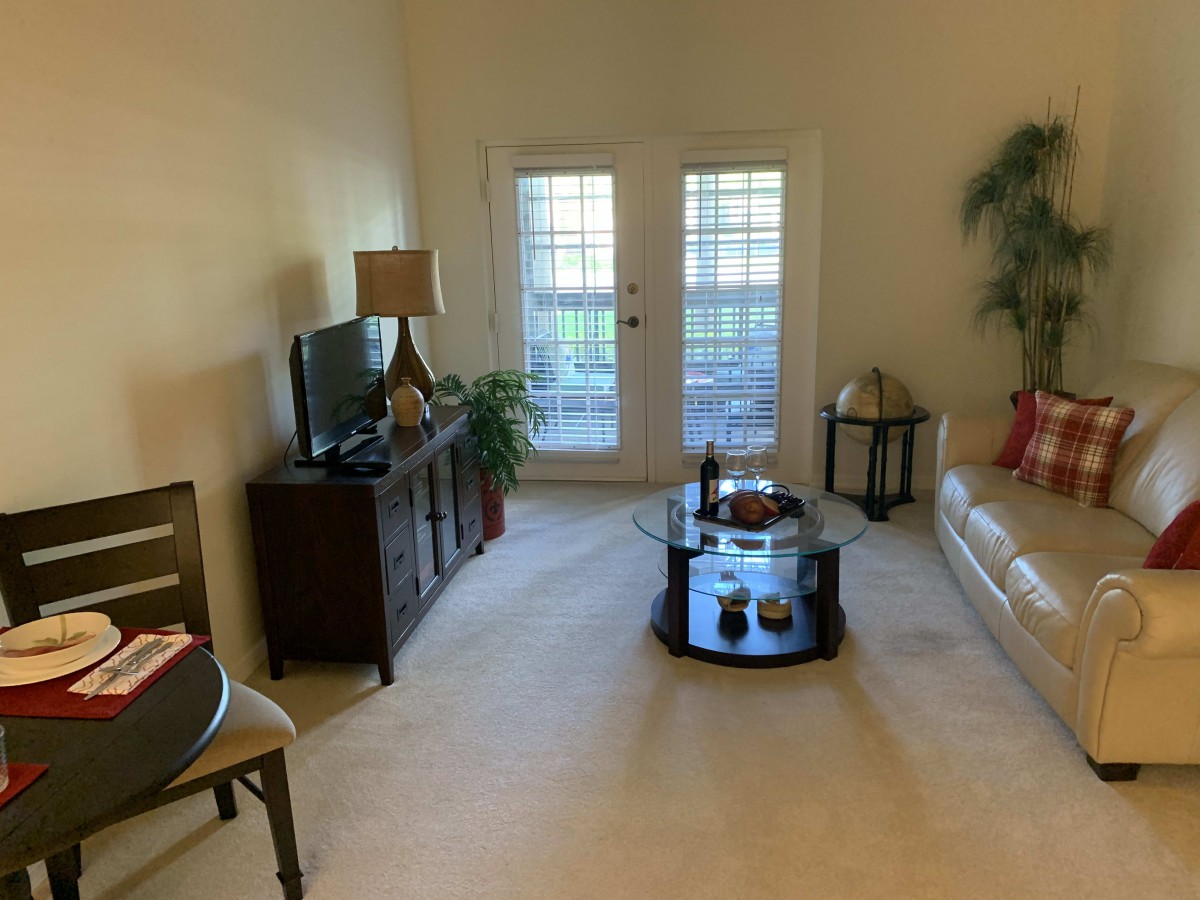 A cozy living room with a sofa, coffee table, and TV, featuring homey decor.