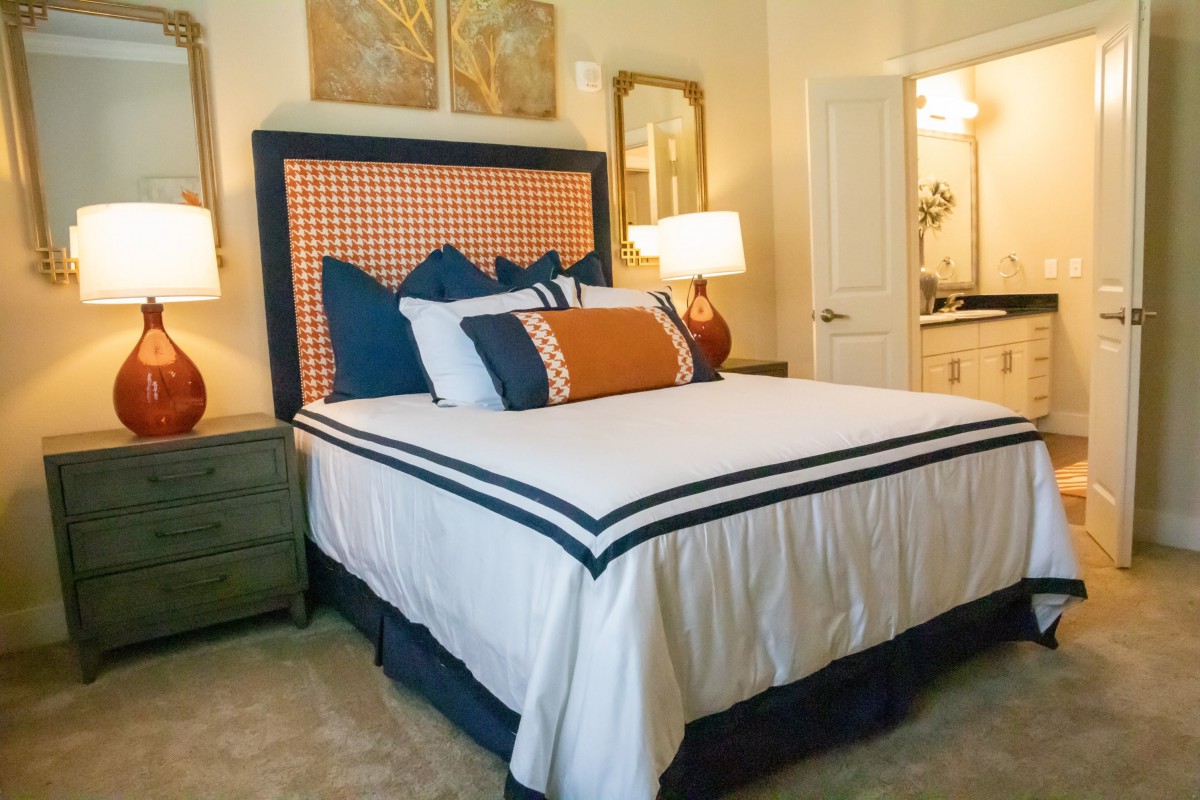 A well-decorated bedroom with a neatly made bed and stylish lamps.