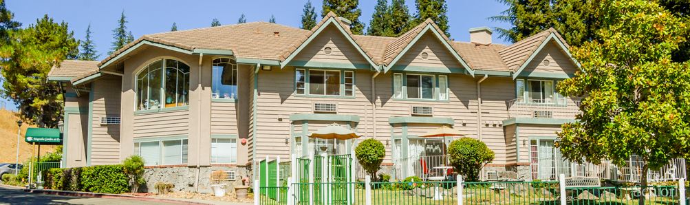 A suburban duplex with green accents and a manicured lawn.