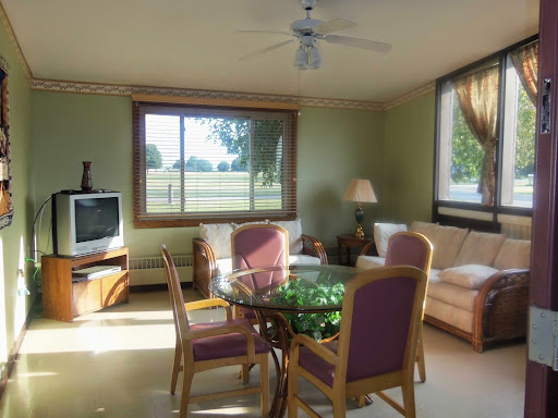 A cozy living room with a scenic view, featuring a glass dining table and comfortable seating.