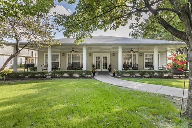 A charming home with a welcoming porch and lush green lawn.