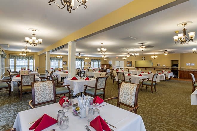 A spacious dining room with elegantly set tables and classic decor.