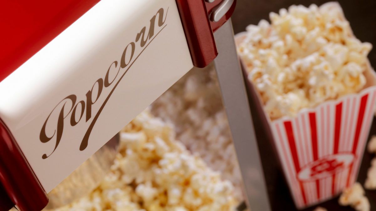 A close-up of a popcorn machine filled with freshly popped popcorn.