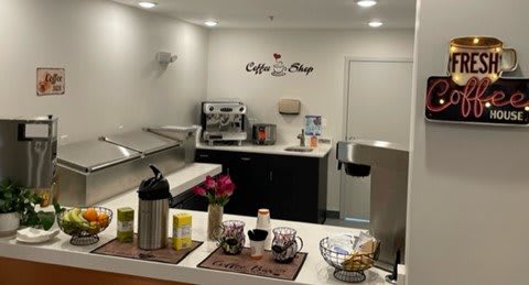 A cozy coffee shop interior with a counter, coffee machines, and decorative elements.