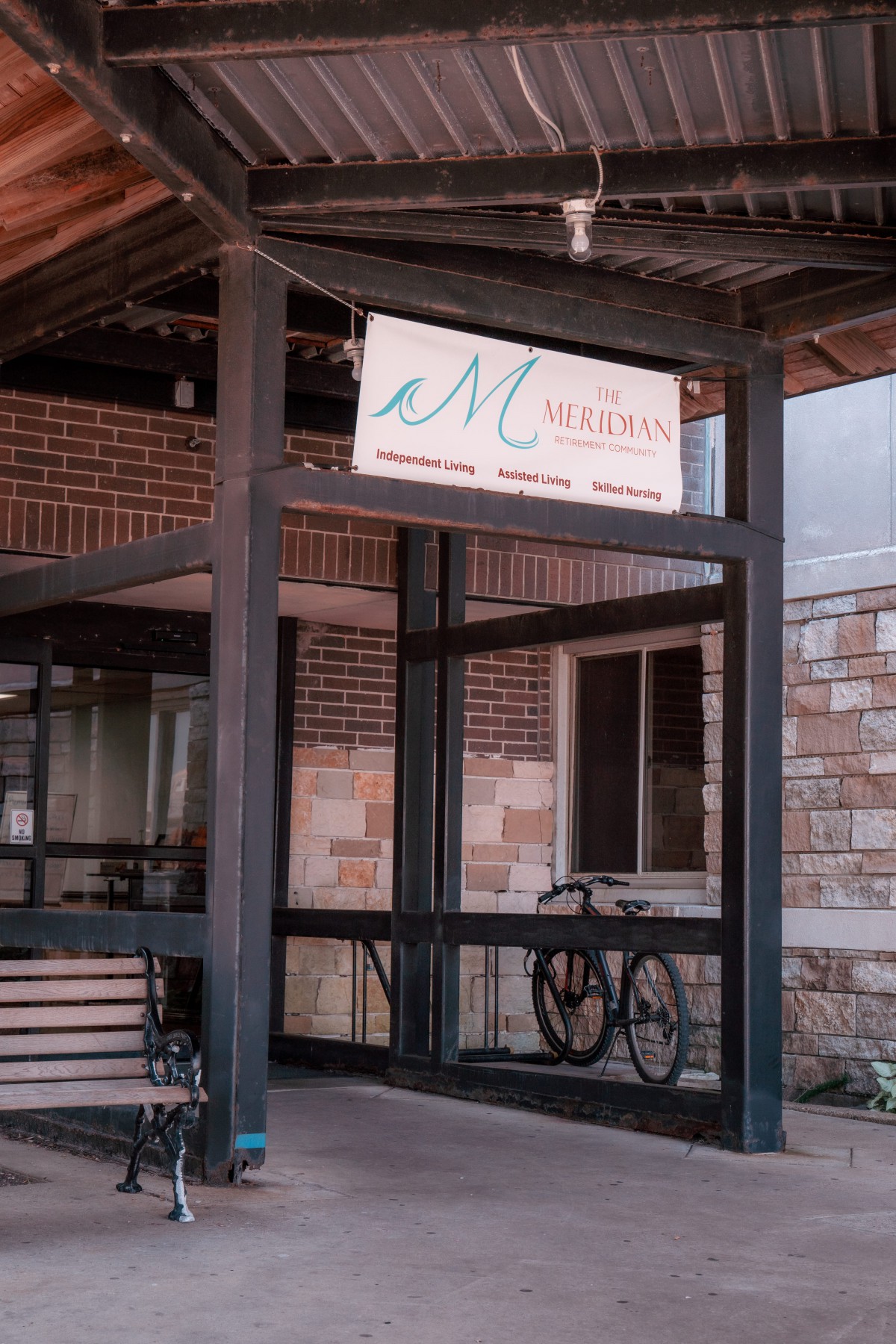 Entrance with a bicycle parked near glass doors and visible signage.