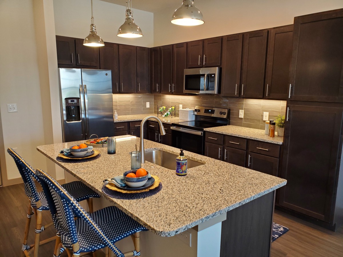A modern kitchen with an island and stainless steel appliances.
