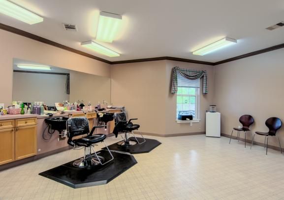 A spacious hair salon interior with styling stations and chairs.