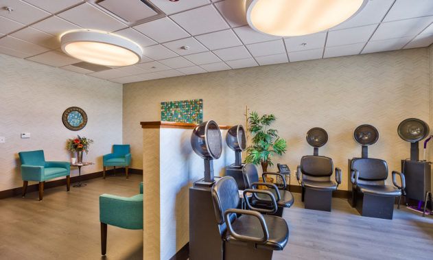 A modern salon interior with hair drying stations and a comfortable waiting area.