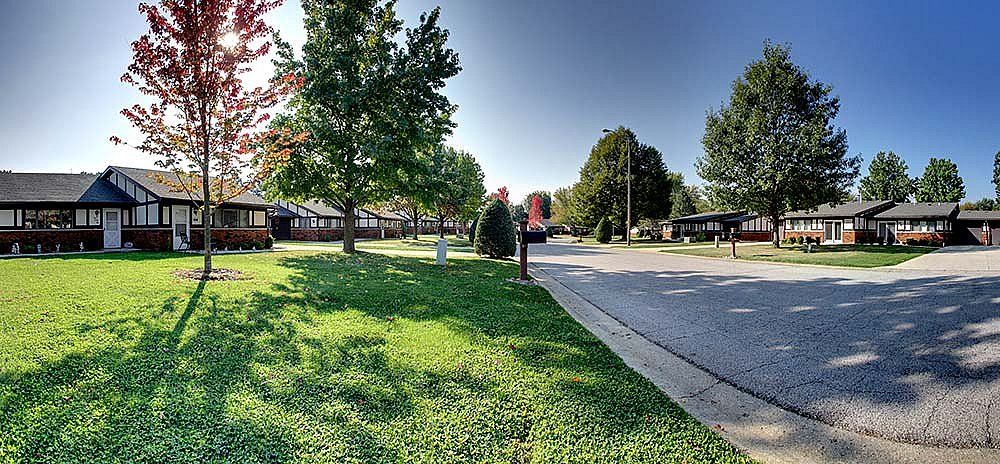A peaceful suburban street lined with trees and houses.
