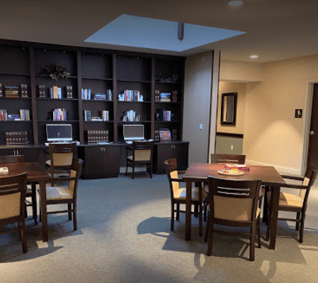A library study area with bookshelves, computers, and tables for reading.