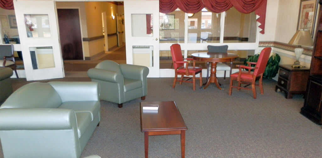 A cozy lobby area with chairs and a table.