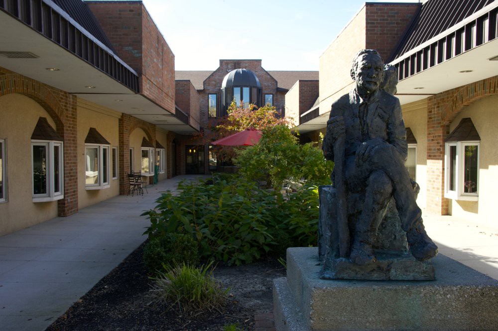 A courtyard with a statue and surrounding architecture.