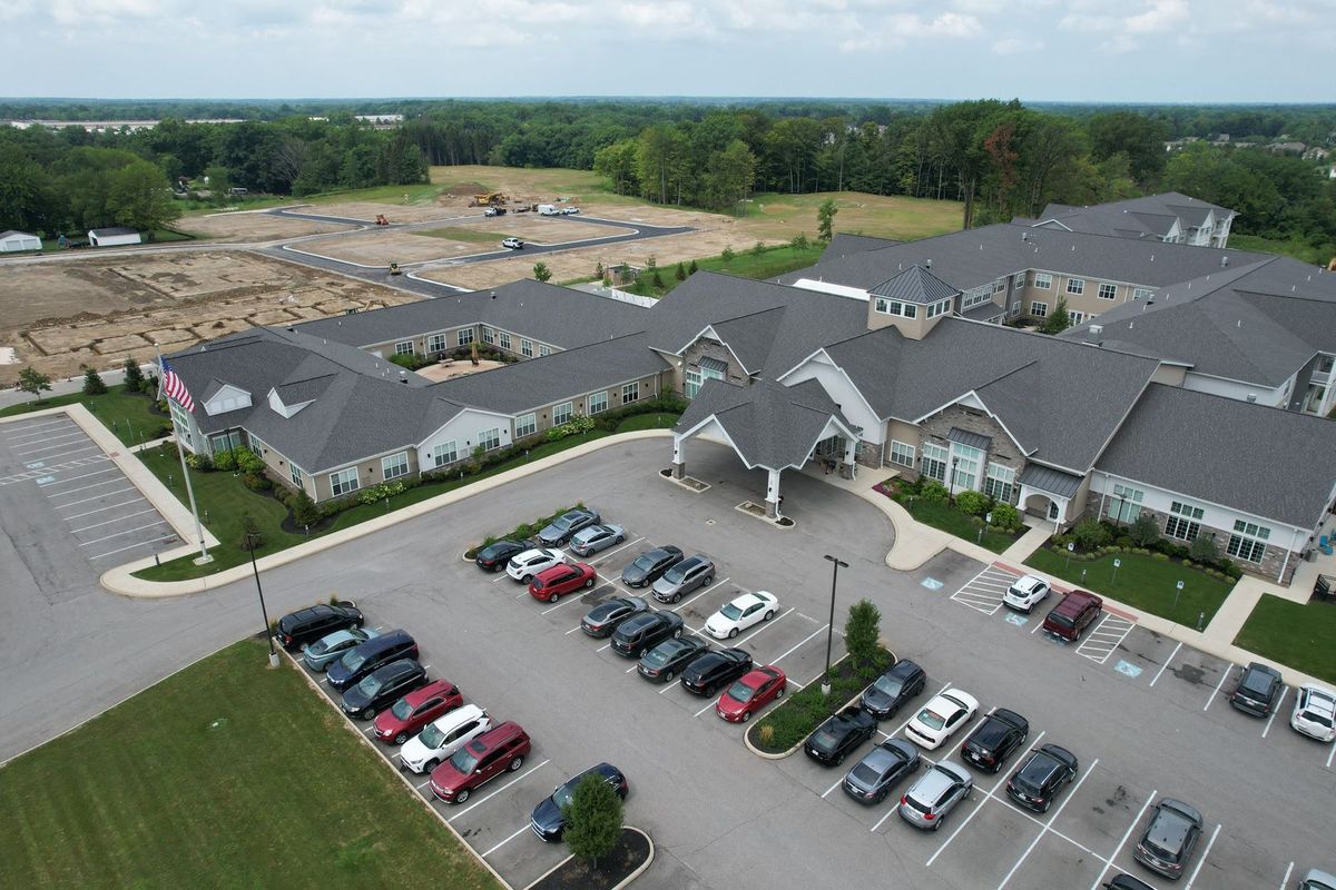 Aerial view of a senior living facility with surrounding parking area.