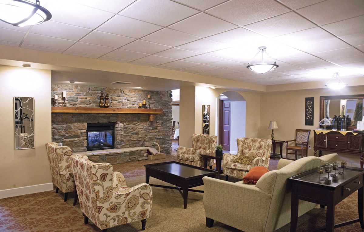 A cozy living room with a stone fireplace and comfortable seating arrangements.