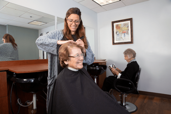 A hair stylist cutting a customer's hair in a salon.