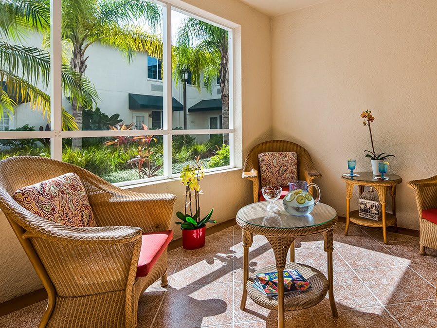 A cozy sunroom with wicker furniture and lush garden views.