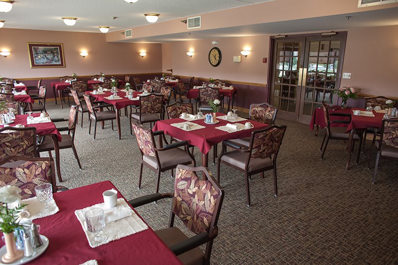 An empty dining room with neatly set tables and chairs, ready for guests.