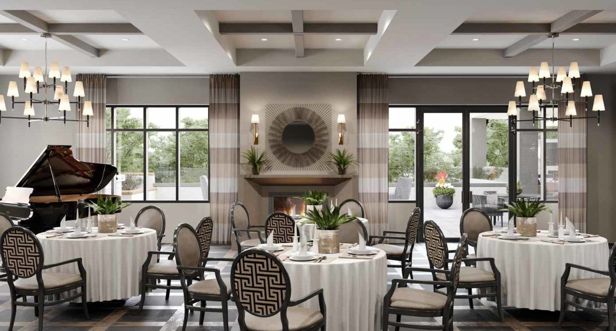 An elegantly designed dining room with neatly arranged tables and chairs, featuring a central fireplace and ample natural light.