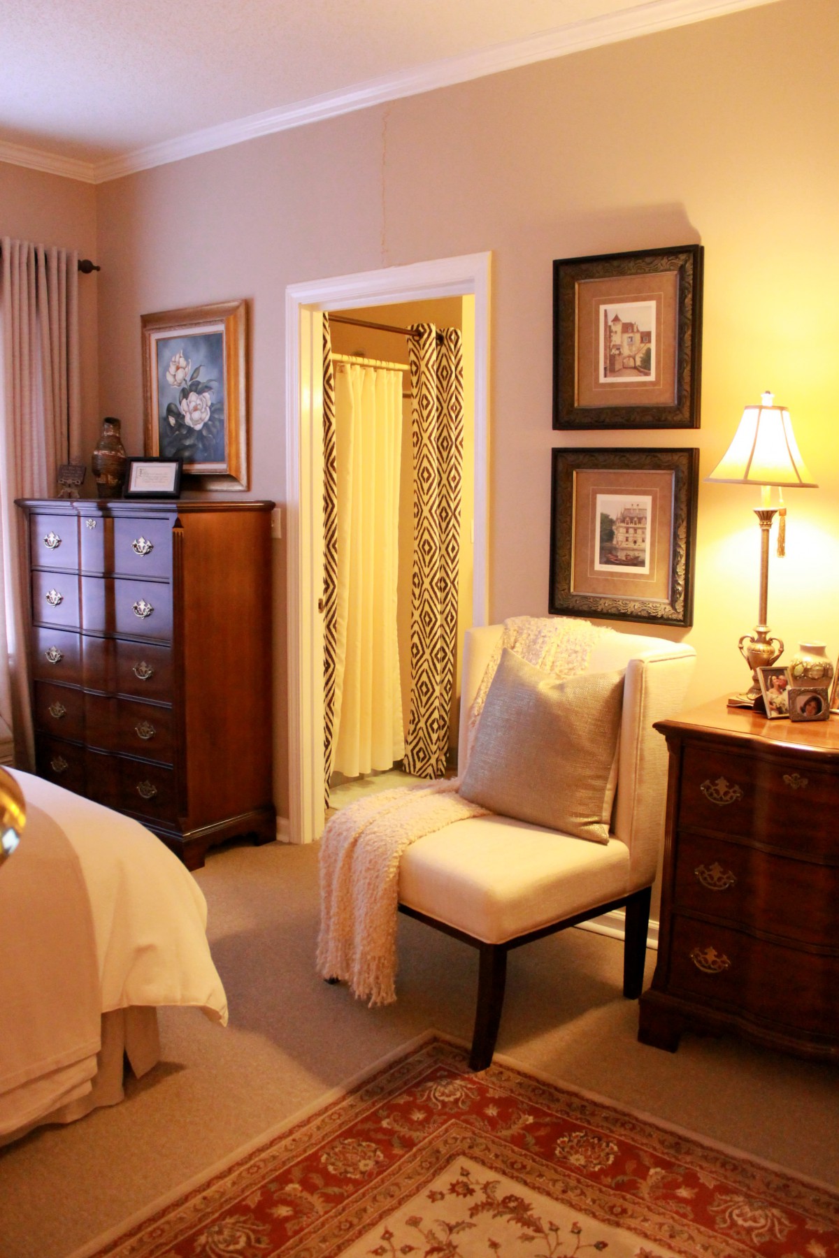 A cozy bedroom with elegant furniture, warm lighting, and tasteful wall art.