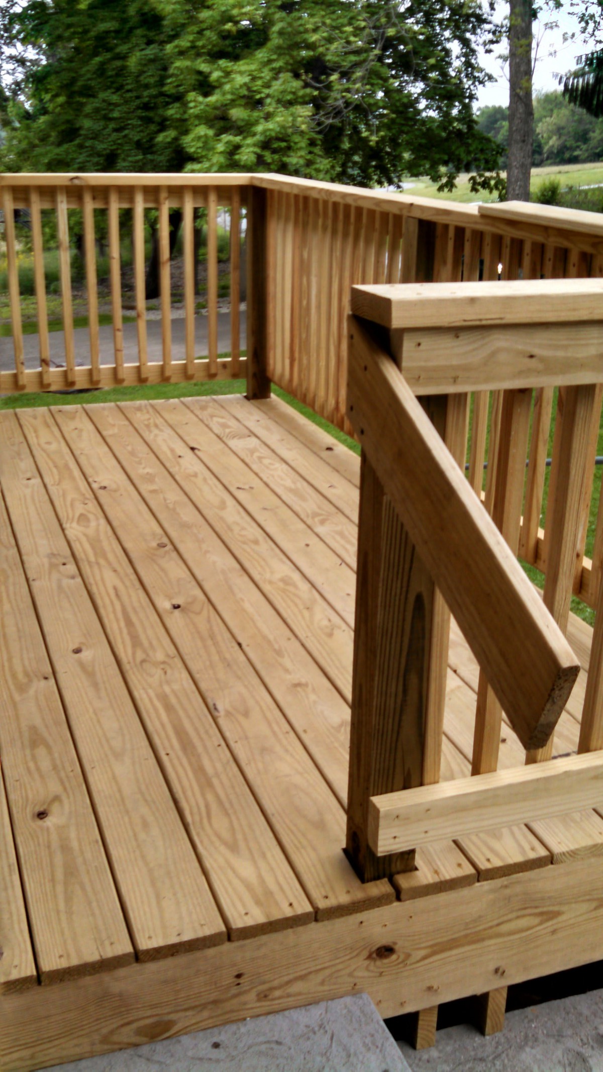 A wooden outdoor deck with railings.