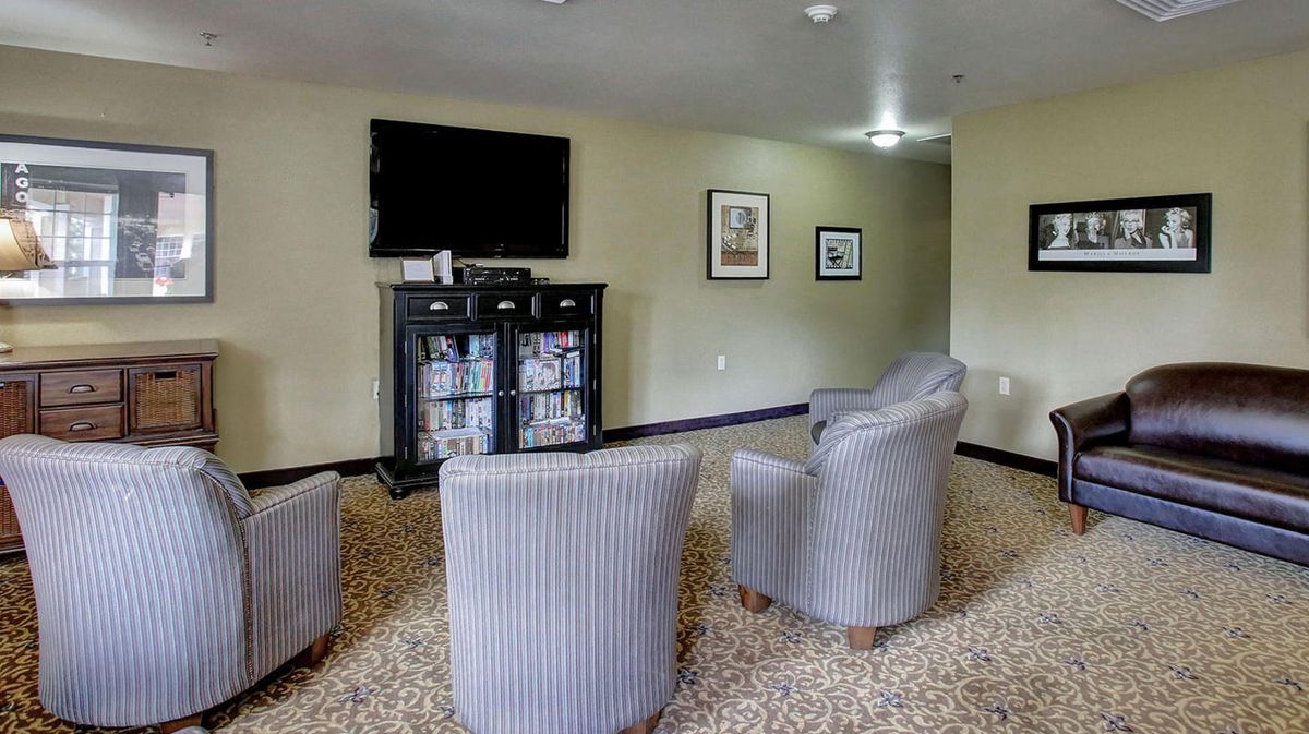 A modern lounge area with comfortable chairs and a wall-mounted television.