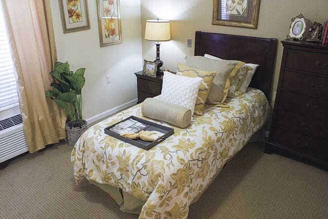 A cozy and elegantly decorated bedroom with floral bedding and soft lighting.