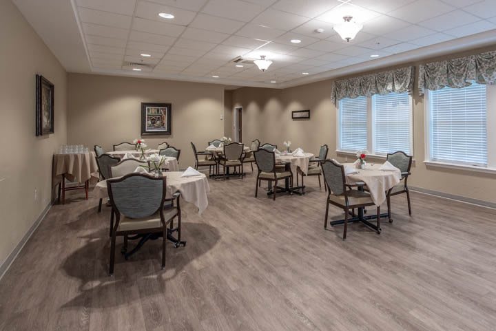 An empty dining room with neatly arranged tables and chairs.