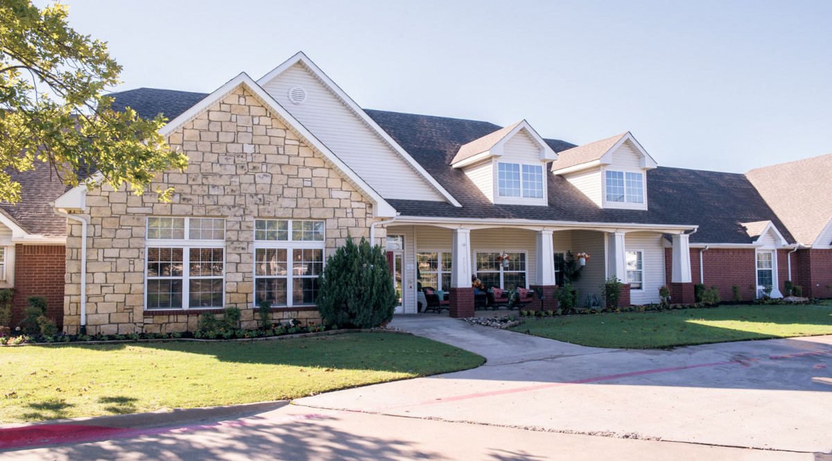 A spacious suburban house with a stone facade and a welcoming front porch.