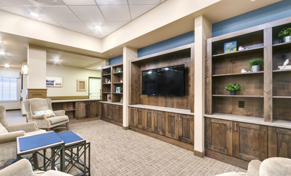 Modern living room setup with a large television and built-in shelving.