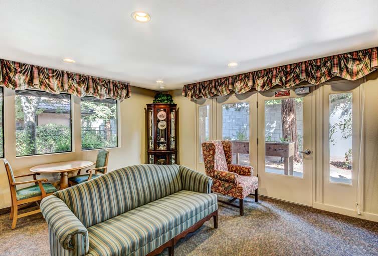 Cozy living room with striped sofa, armchair, and large windows.