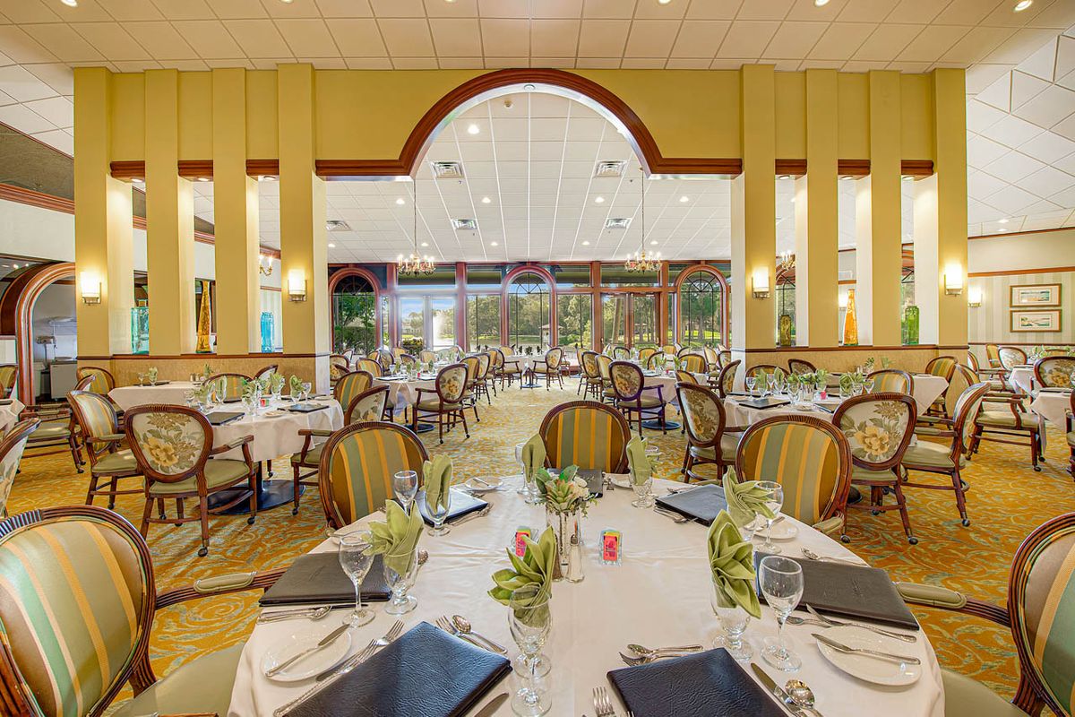 An elegant dining room with neatly arranged tables and chairs, featuring stylish decor and place settings.