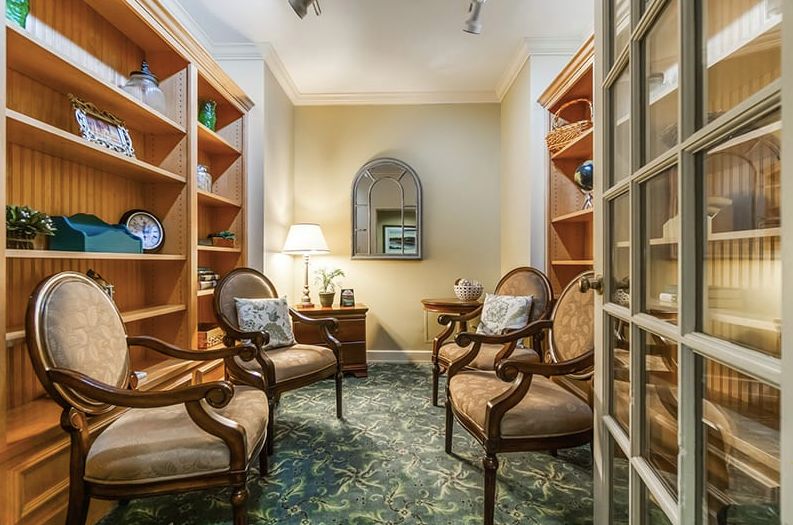 A cozy sitting area with armchairs and bookshelves.