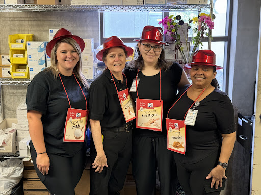 A cheerful group of people wearing red hats and black outfits, ready for a fun event.