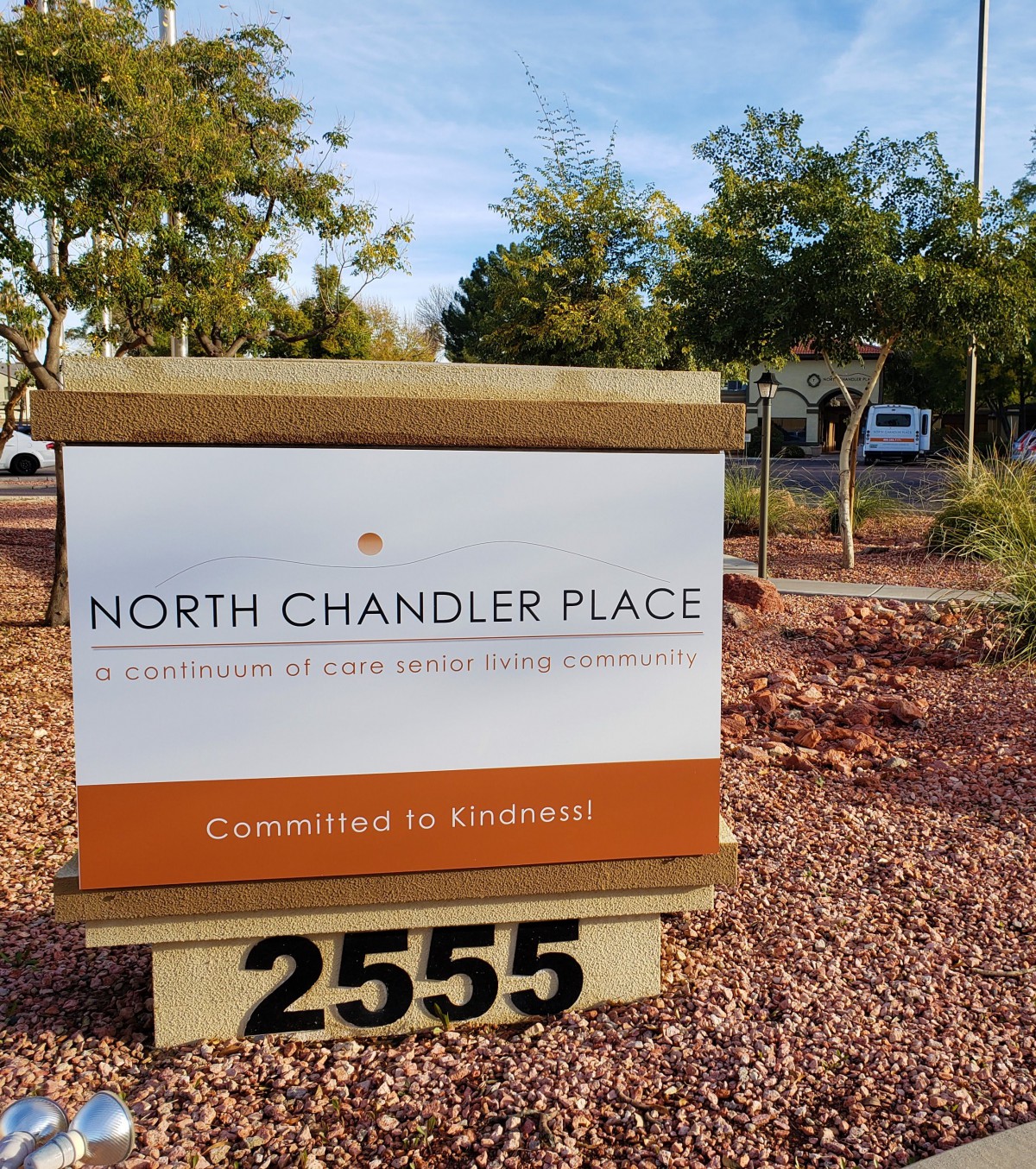 A sign for North Chandler Place with an address of 2555, located in a landscaped outdoor setting.