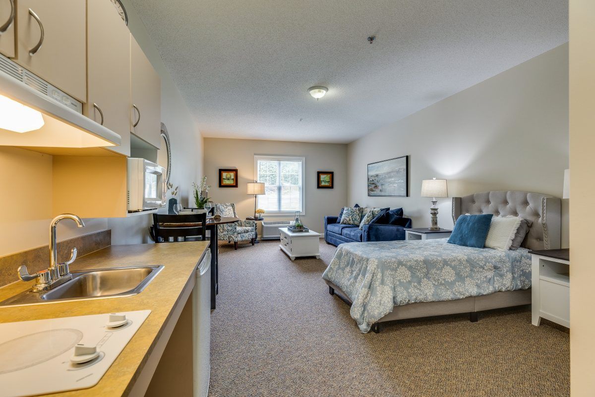 A cozy and well-furnished bedroom with a sitting area and kitchenette.