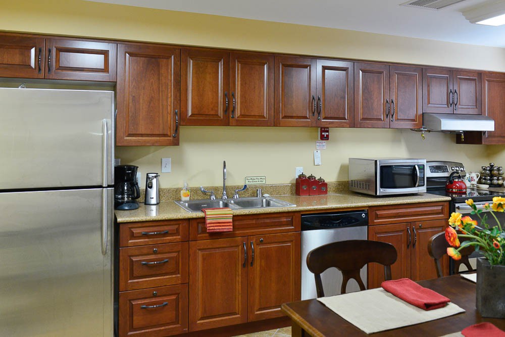 A modern kitchen with wooden cabinets and stainless steel appliances.